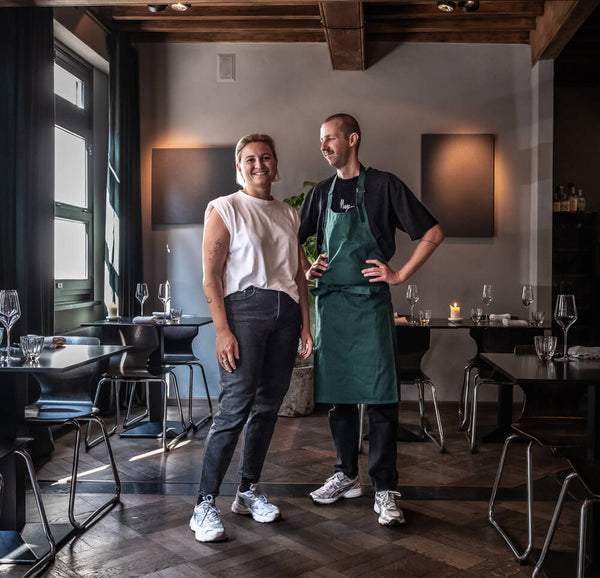 Op een boogscheut van het Centraal Station hebben Niki en Koen zich geïnstalleerd in een voormalige drukkerij, vandaag een elegant restaurant onder hoge plafonds met houten balken. Aan het roer staat chef Koen, wiens Frans-moderne keuken bewerkt en bij momenten origineel is, maar waar het vooral de natuurlijke smaken zijn die voor zich spreken. Zo laat hij tarbot een week rijpen voor hij de vis boven open vuur roostert en combineert met grelotajuin gegaard in rode wijn, shiitake met een vleugje room, een puree Robuchon en een verfijnde saus van fumet en gerookte paling. Gastvrouw Niki blinkt uit in haar kennis van natuurwijnen, die de creaties van de chef nog accentueren. De plekjes aan de counter bij de grote houtoven zijn zeker de moeite waard.